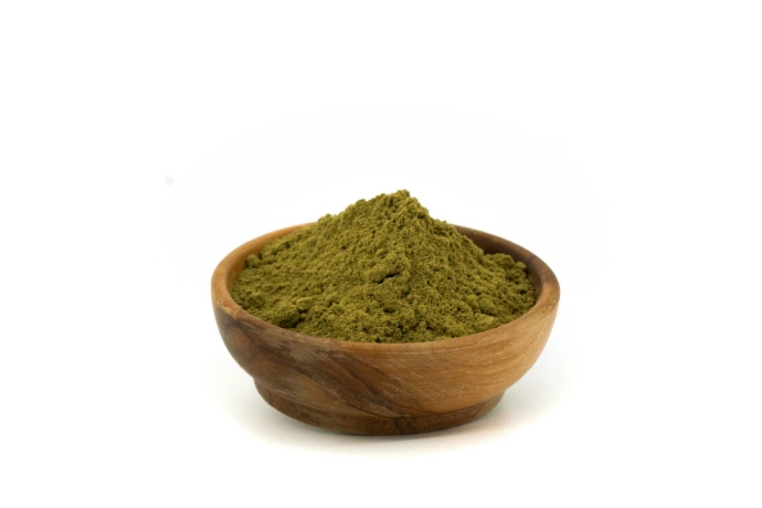 Green powder in a wooden bowl.